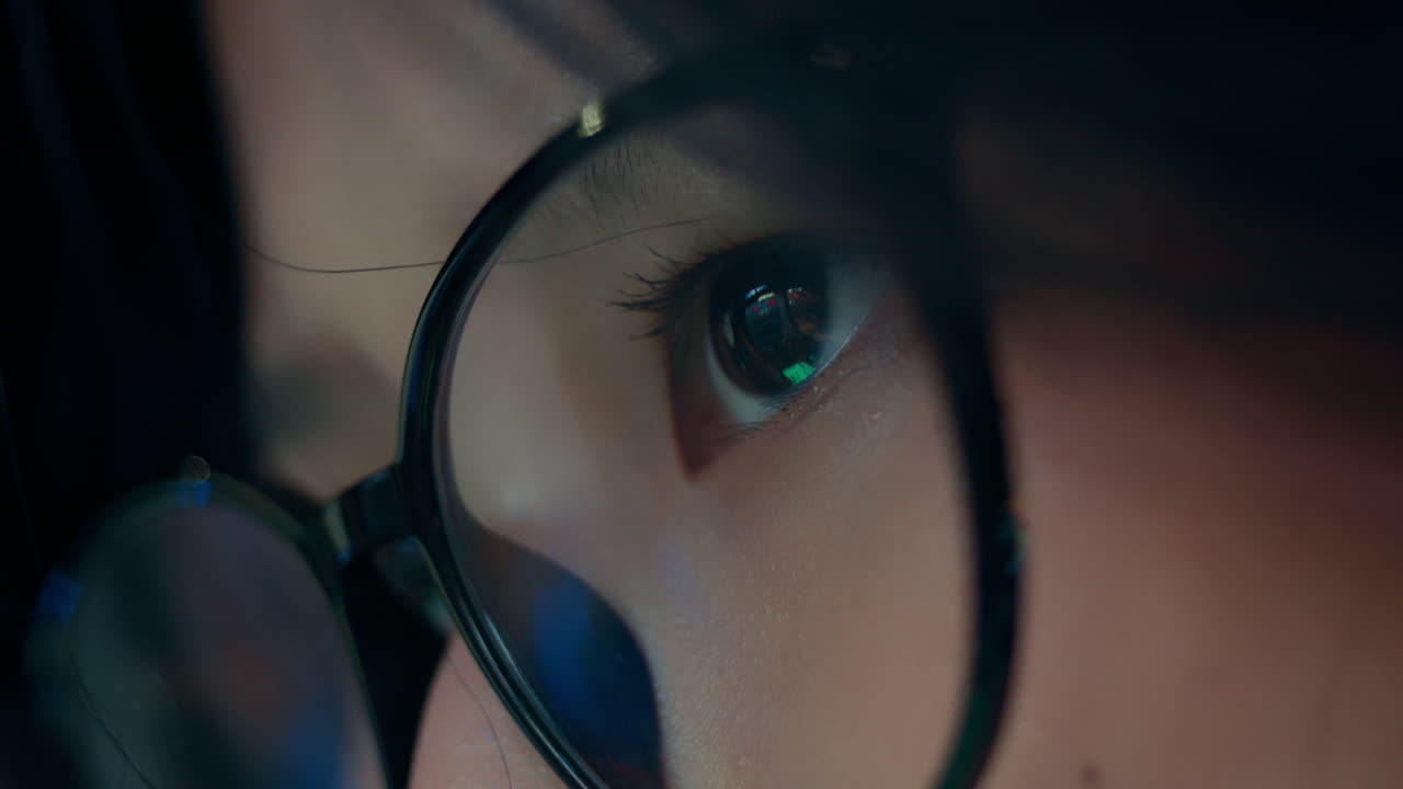 primer plano detallado de la chica con gafas, seguimiento de los ojos siguiendo el reflejo de la pantalla