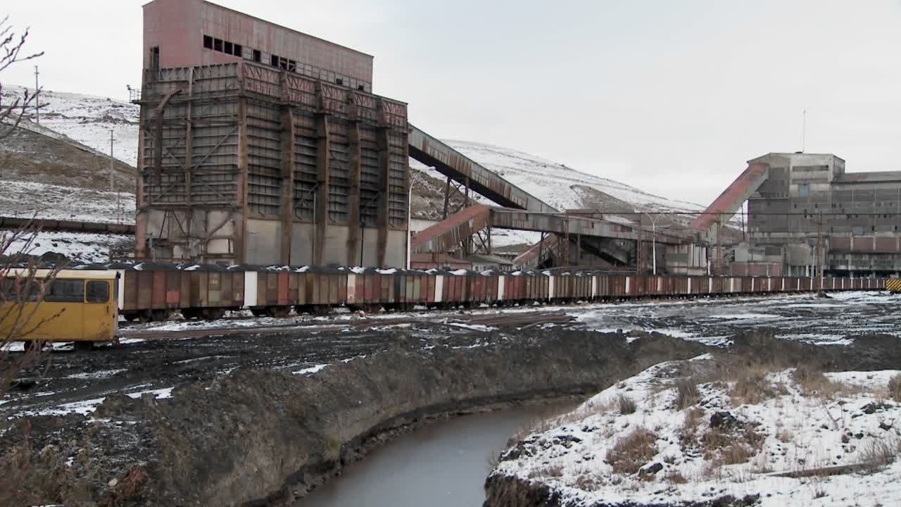 전경에 광석 열차가 있는 버려진 광산을 가로질러 이동