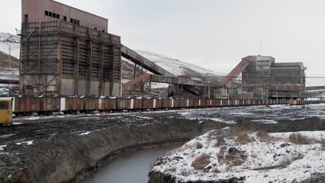 Schwenk-über-Ein-Verlassenes-Bergwerk-Mit-Erzwaggons-Im-Vordergrund