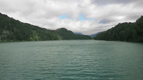 Low-aerial-flight-over-Espejo-Lake-Patagonia,-under-heavy-cloud-sky