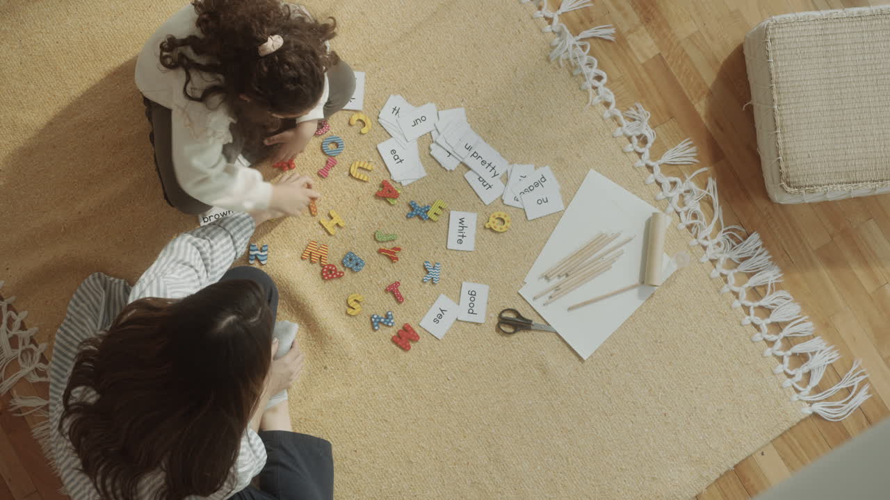 Mother and Little Daughter Playing Educational Game at Home