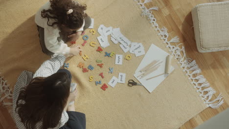 mother and little daughter playing educational game at home