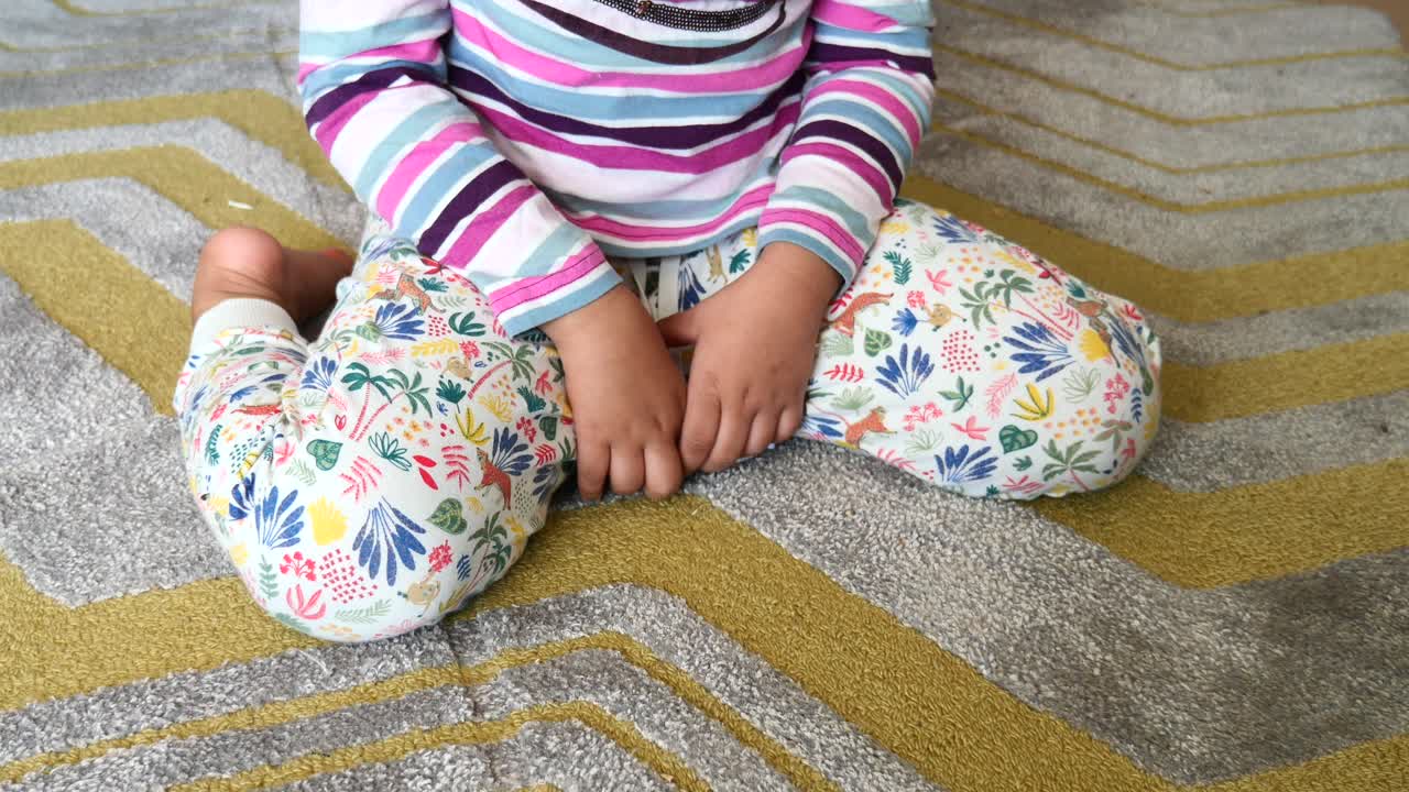 niño sentado en una alfombra estampada