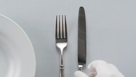 Elegant table setting with white tableware plates, cutlery, and glassware for a classy dining, fancy expensive restaurant dinner