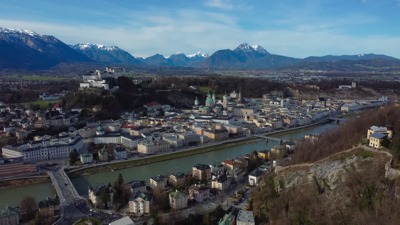 Cinematic drone video of mind-blowing cityscape of Salzburg with Fortress and Snowy Alps in background - Austria