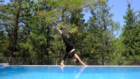 una mujer haciendo yoga junto a la piscina