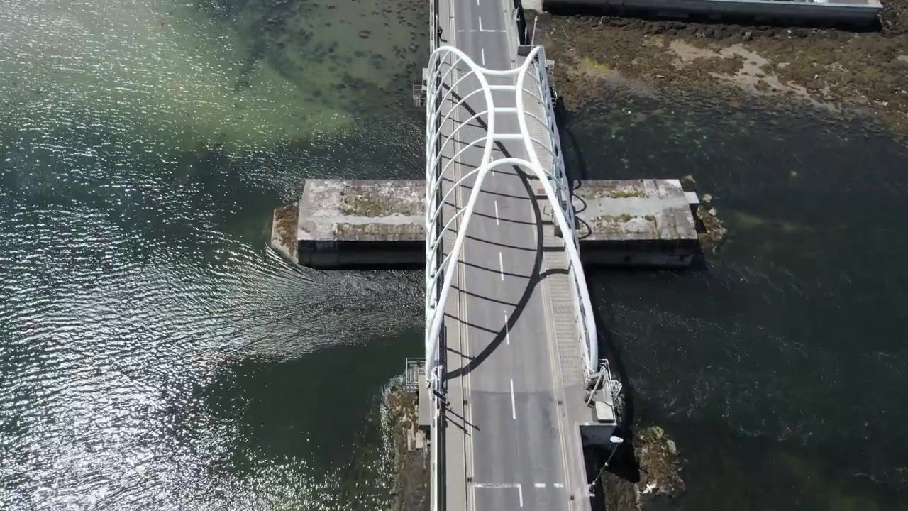 Voando sobre a ponte que conecta a Ilha Achill ao continente irlandês em um dia ensolarado de verão, tomada de drone