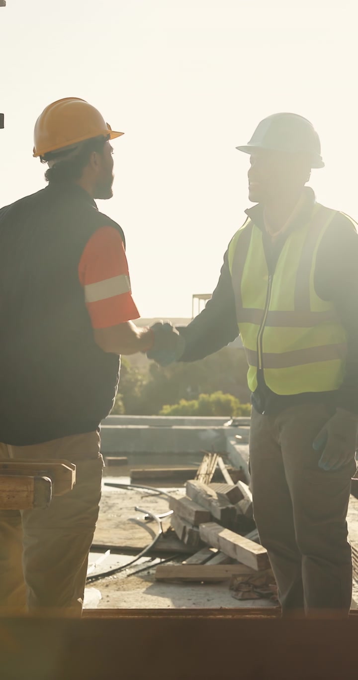 Construction Workers Shaking Hands on Building Site