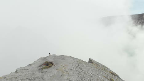 Person,-Die-Den-Rand-Des-Ijen-vulkans-Mit-Dichtem-Schwefelrauch-Aus-Dem-Krater-Erkundet