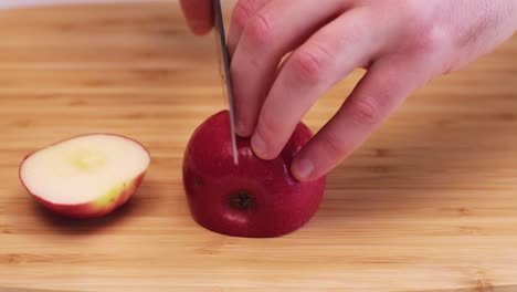 close up of a red apple being cut into chunks