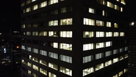 Closeup-of-business-office-skyscraper-in-downtown-Toronto,-night-aerial