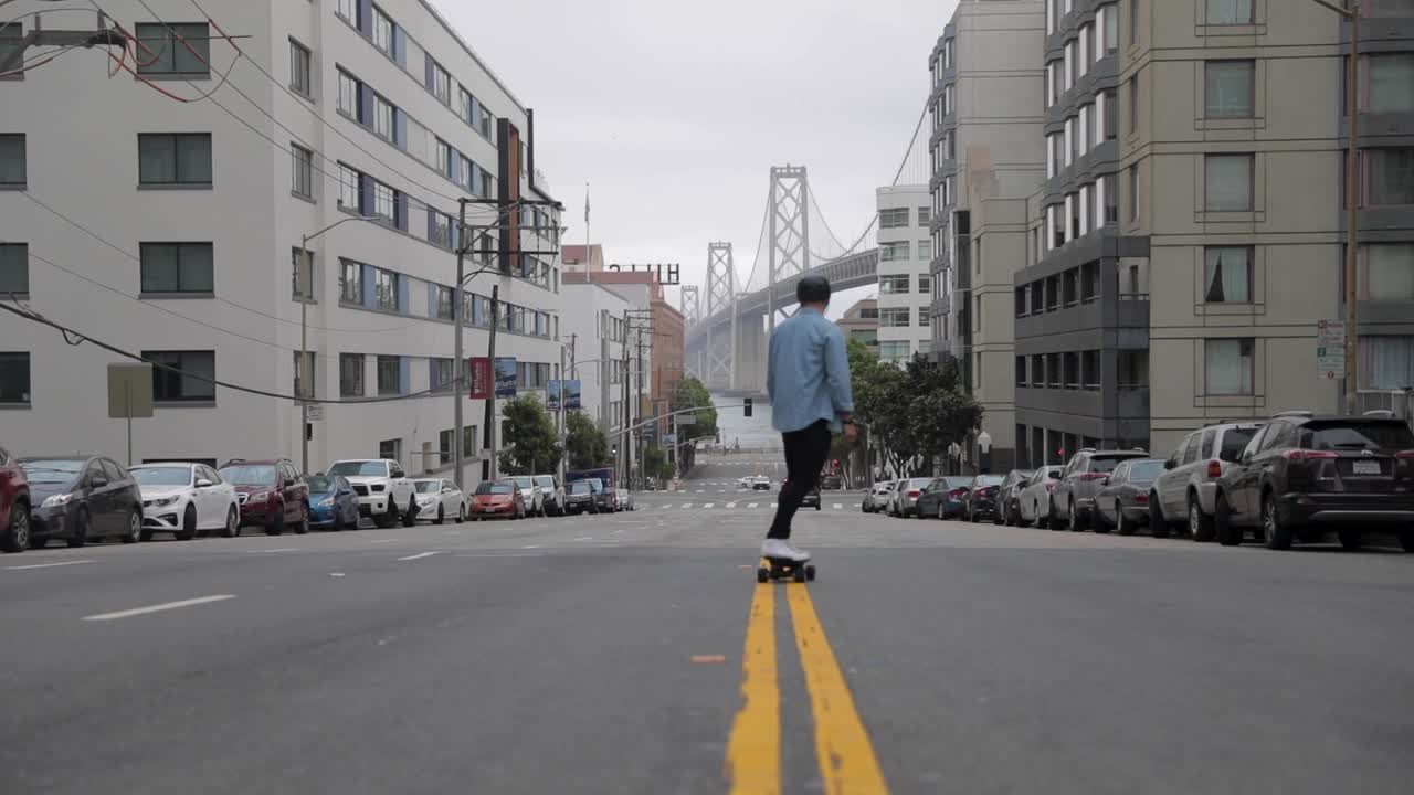 샌프란시스코의 베이 브리지를 향해 스케이트보드 타기