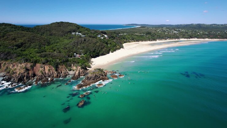 Drone che orbita attorno a The Pass Beach a Byron Bay in una mattina splendidamente calma