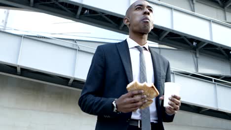 young businessman with sandwich and paper cup