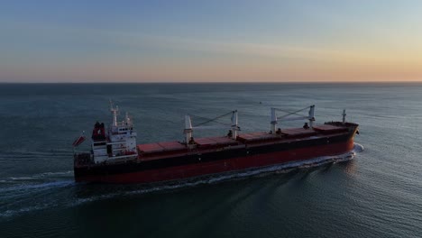 an impressive bulk carrier vessel sailing onwards to next destination, aerial