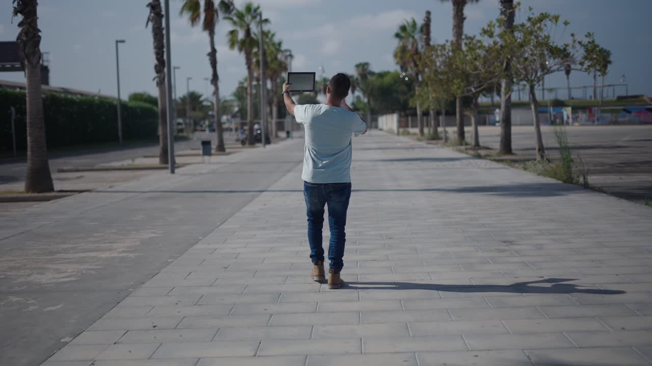 Man Walking Outdoors with Tablet
