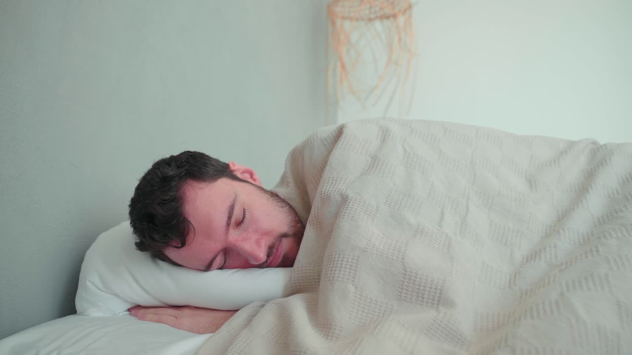 hombre dormido, blanco caucásico con barba, joven acostado en la cama durmiendo soñando, almohada incómoda, voltearse en el sueño