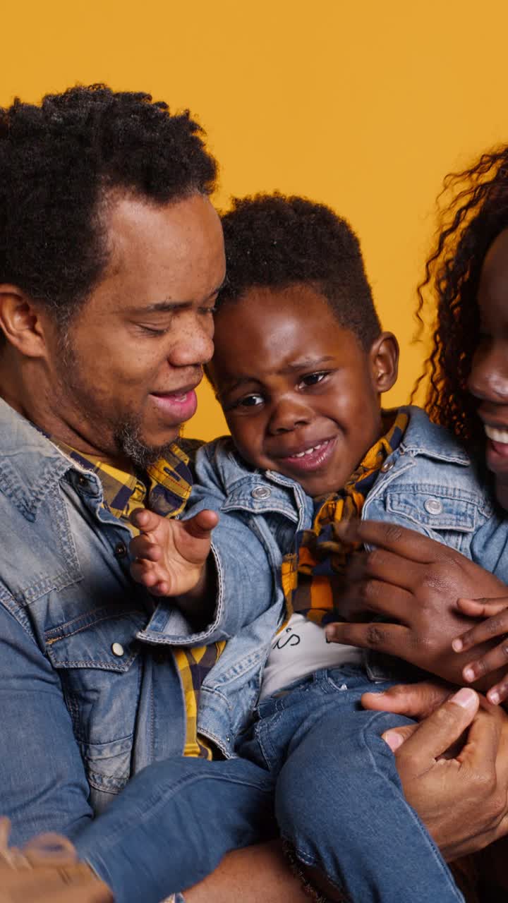 Felice famiglia afroamericana che gioca con il figlio in studio