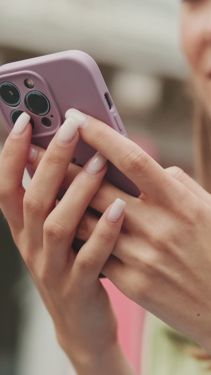 Primo piano delle mani che usano uno smartphone viola