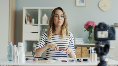 pretty beauty blogger recording a makeup tutorial video and talking about lipglosses 2