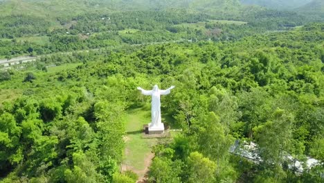 drone shot of mount zion pilgrim mountain with a gigantic scuplture of jesus christ behind a scenic mountain