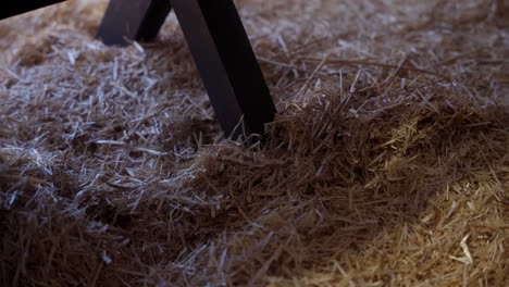 the leg of a manger sitting in hay at night