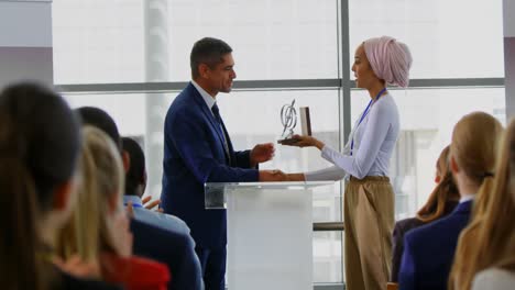 Businessman-receiving-award-from-businesswoman-in-the-business-seminar-4k