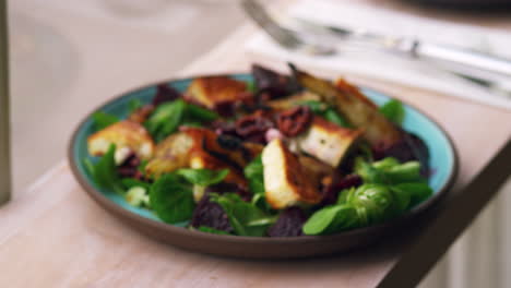 Baked-goats-cheese-and-pear-salad-by-a-window,-rack-focus