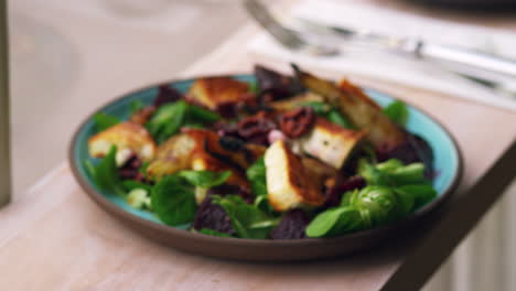 baked goats cheese and pear salad by a window, rack focus