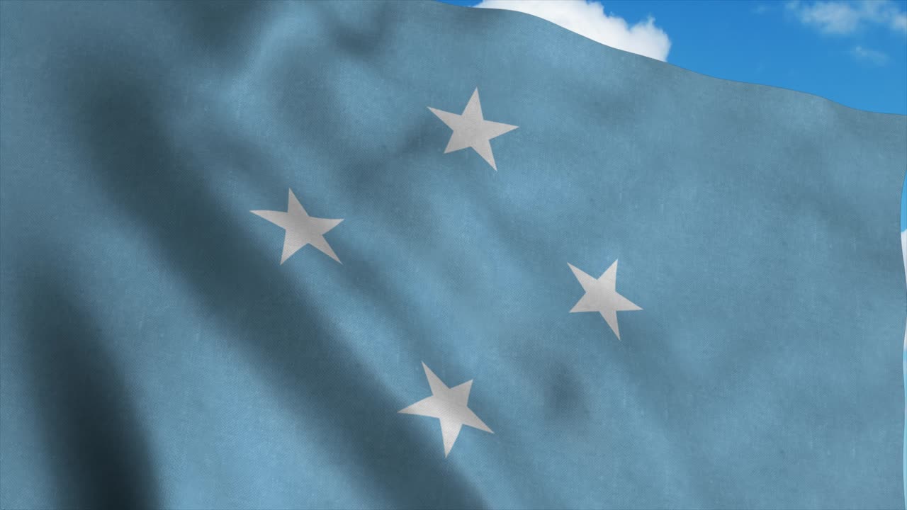 Micronesia flag on a flagpole waving in the wind, blue sky background. 4K