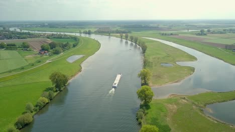 aerial drone view flying over the container shipping ship at the river in the netherlands, europe