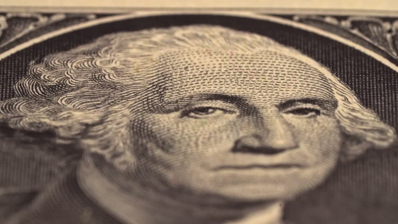Close view of a one dollar bill showing the portrait of George Washington