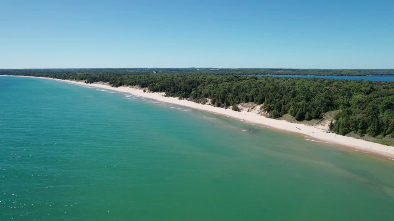 Drone shot flying to the left of whitefish dune state park shoreline