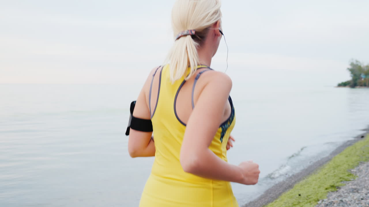 잔잔한 물가에서 조깅하는 여자