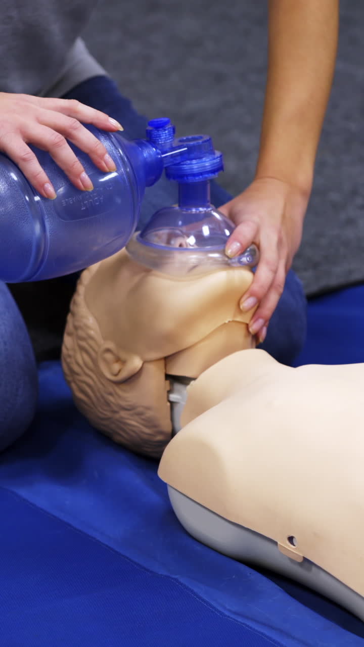 Cardiopulmonary resuscitation. Instructor demonstrates first aid reanimation on a dummy. Medical worker shows cardiac exercise on a mannequin. Vertical video