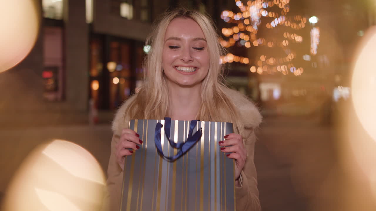 Una giovane e attraente donna bionda ti consegna il regalo che ha scelto per te.