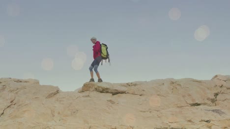 animación de puntos de luz sobre mujer caucásica caminando en las montañas