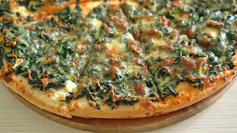 Pizza de espinacas y queso en bandeja de madera - estilo de comida vegetariana y vegana
