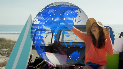 woman in sun hat enjoying beach with digital globe animation over scene