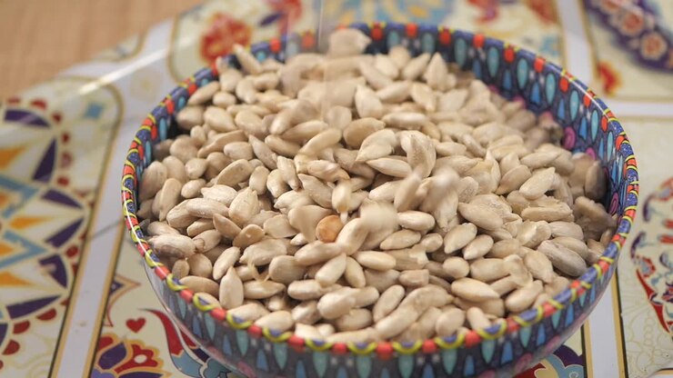 Sunflower Seeds Being Poured into a Colorful Bowl