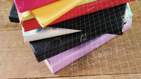 ecuaciones matemáticas sobre líneas de cuadrícula contra pila de libros en superficie de madera
