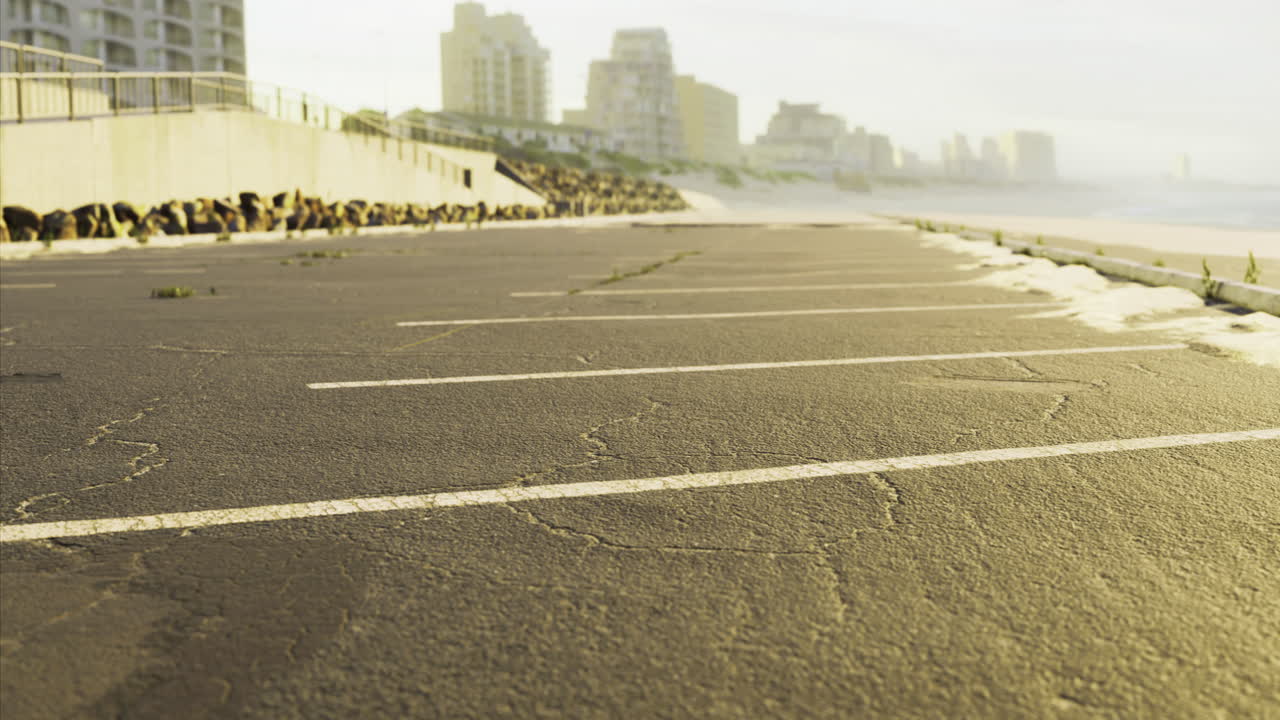 Sunrise over empty parking lot by oceanfront in coastal city