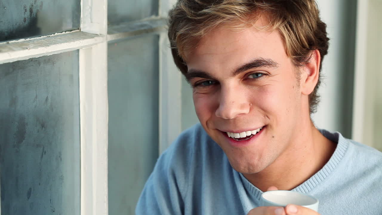 집에서 커피를 마시는 매력적인 남자