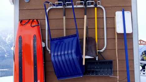 snow clearing equipments hanging against wooden barn 4k