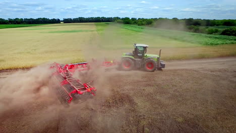 farming tractor with trailer for plowing working on cultivated field