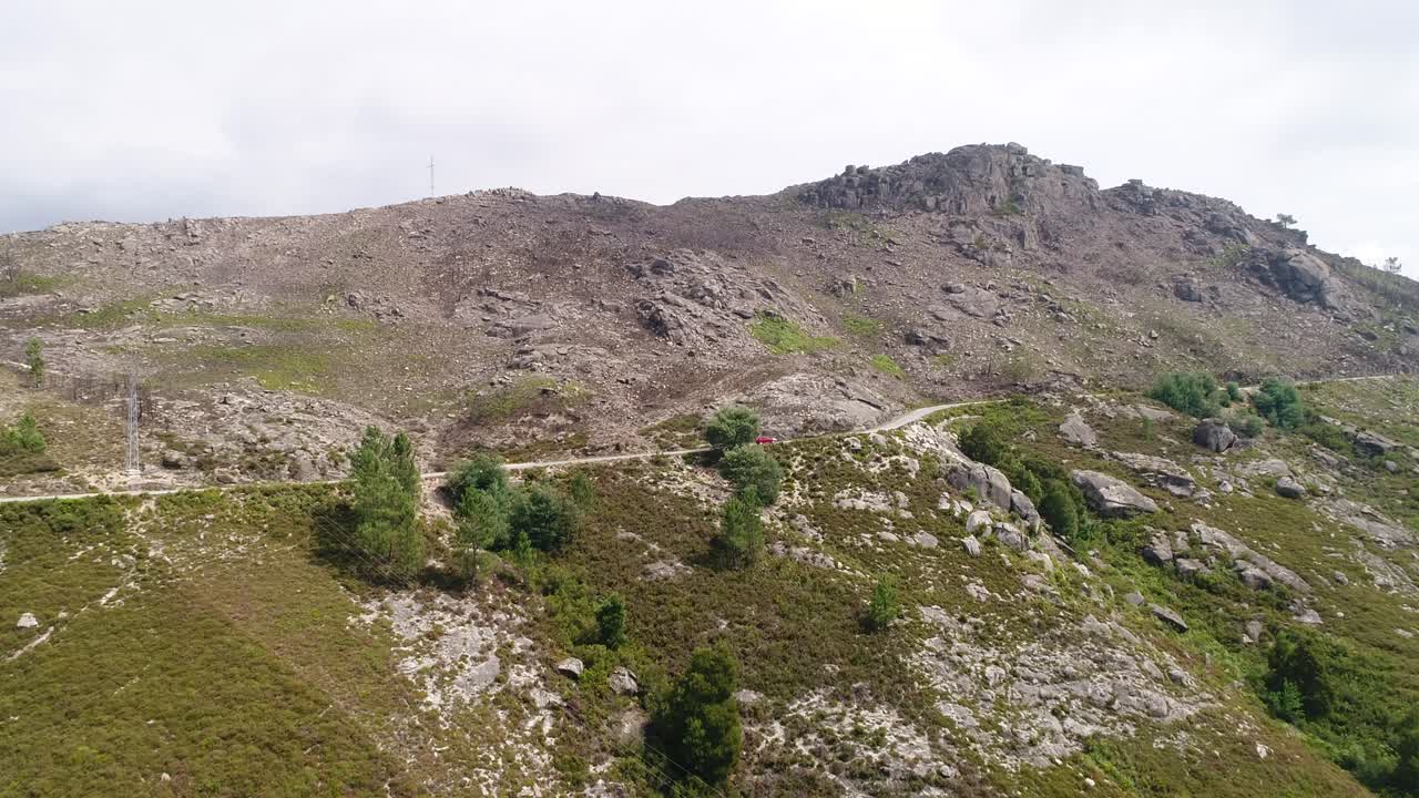 Vista aerea di un'auto che viaggia su una strada tortuosa in alta montagna