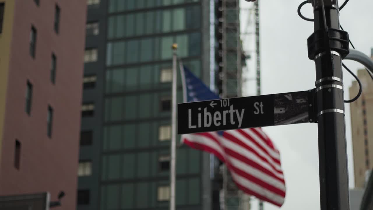 Manhattan, New York. Insegna di Liberty Street con bandiera americana che sventola sullo sfondo. Dettaglio al rallentatore