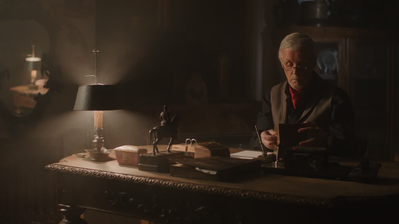 Older passionate antique dealer take out an old watch from the wooden box