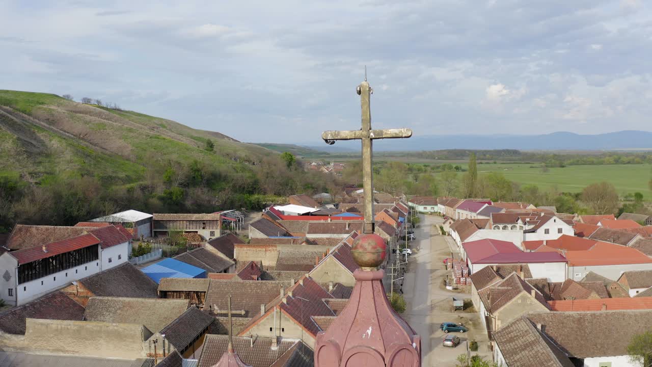 hermoso tiro de una cruz en una gran iglesia en el medio de un pequeño pueblo