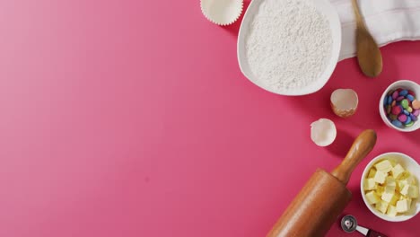 video of baking ingredients and tools lying on pink surface with copy space